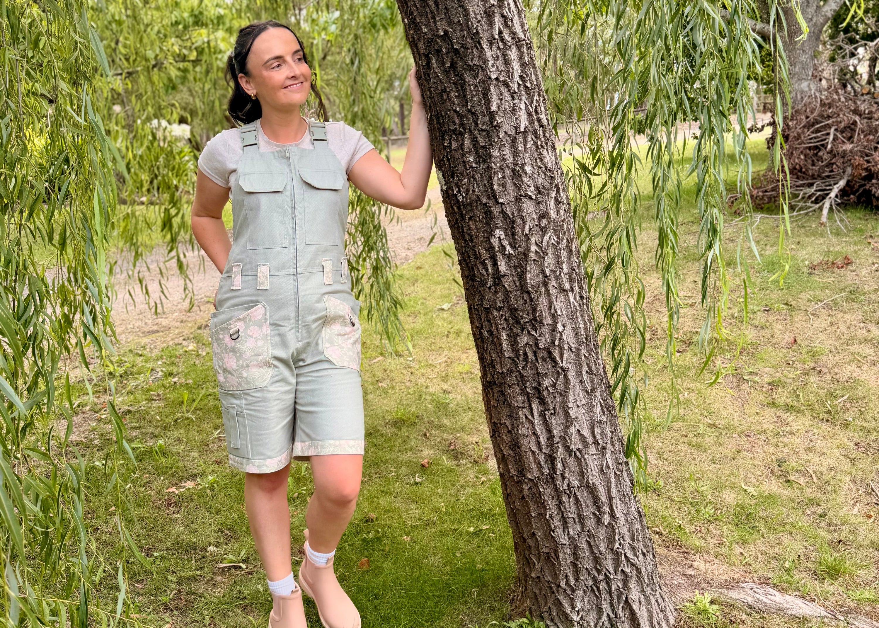 Woman in Peony Patch Shortalls standing under a willow tree