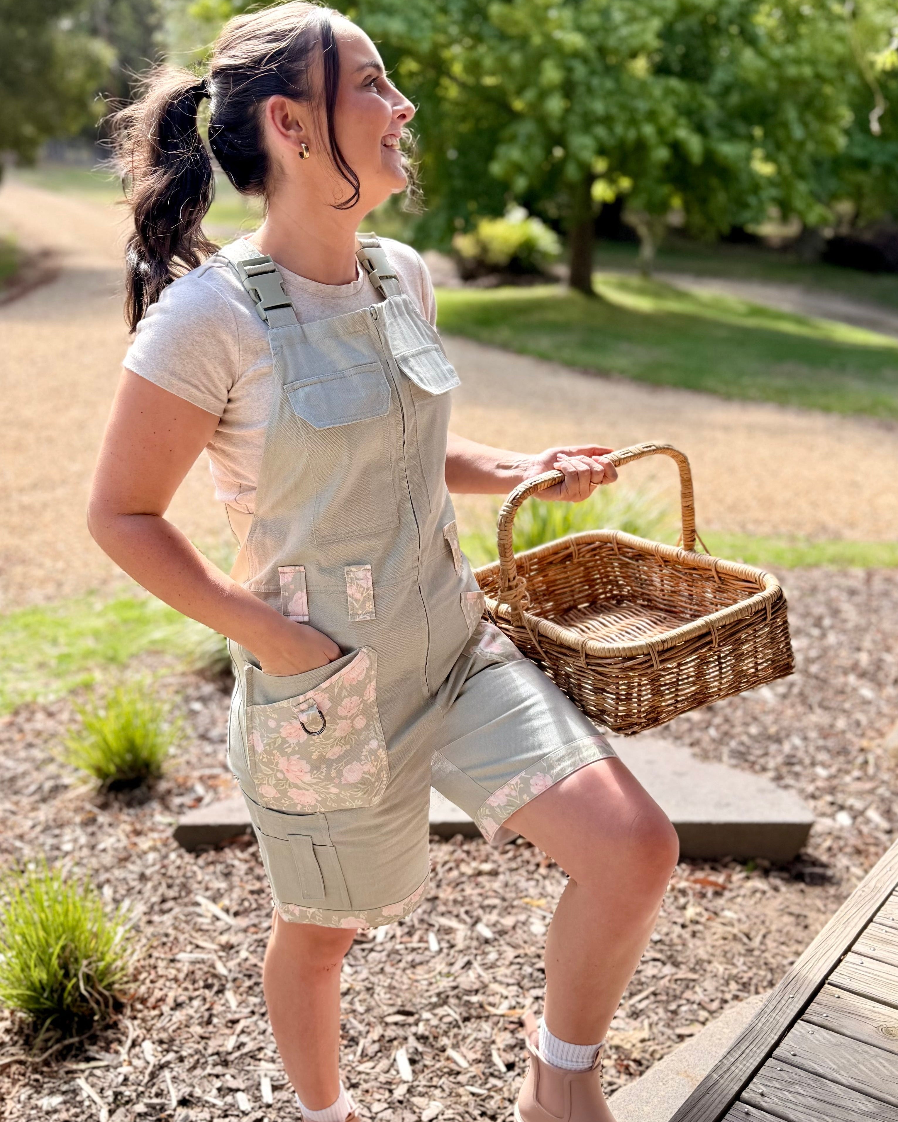 Woman in Peony Patch Shortalls standing on porch steps holding a wicker basket